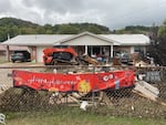 Trudy Hall lost all her furniture to flooding and a volunteer is hauling it away to the dump.