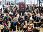 Passengers wait in front of check-in counters at the capital's Berlin Brandenburg Airport, in Schönefeld, Germany, on Friday after a widespread technology outage disrupted flights, banks, media outlets and companies around the world.