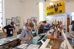 Melissa Talmadge-Cox, Buster Keaton's granddaughter, looks at photographs from the filming of the 1926 silent film "The General" with 2026 Buster Keaton Conference attendees at the Cottage Grove Museum in Cottage Grove, Ore., on Saturday, Aug. 29, 2026. (Krista Rossow for NPR)