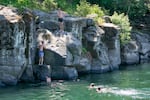 A group of people jump into the Clackamas River at High Rocks Park to stay cool in Gladstone, Ore., July 15, 2025. 