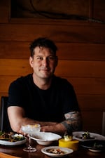 Joshua Dorcak, chef and owner of MÄS in Ashland, Ore., seated in front of assorted dishes.