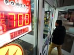 A patron enters a liquor store as a sign displays the Powerball jackpot, Tuesday, Oct. 25, 2022, in Baltimore.