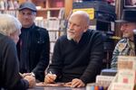 Eric Alexandrakis (background), John Malkovich and Sandro Miller (right) sign copies of "Like a Puppet Show" for fans at Music Millennium