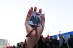 A person holds a picture of Iran's supreme leader Ayatollah Ali Khamenei, who was killed in joint US and Israeli strikes, as people mourn at a square in Tehran on March 1, 2026.