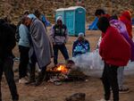 Migrants huddling for warmth at an unofficial detention camp in Jacumba, California. A record number of people have arrived at the US southern border in the last year.