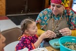 Sequoia Tias, known as Piipš, 3, sorts wild celery with her mother, Michelle Tias, in the Mission Longhouse on March 4. This marks the youngster’s first year digging for the annual celery feast. She keeps her plants separate from the rest and gives them to her grandmother, Shawna Gavin, 65, as a special honor during the ceremonial feast.