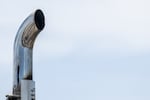 This photo is a close-up of a shiny metal exhaust pipe atop a truck in Austin, Texas.