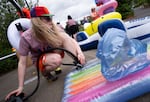 Volunteer Xan Pederson helps people inflate their floats at the inflation station. 