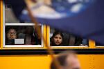 A school bus of children visiting the Capitol drives by the crowd of people attending a rally for climate action in Salem, Ore., Feb. 11, 2020.