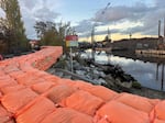 A wall of sandbags lines the Duwamish Waterway in Tattatucid Park in Seattle’s South Park neighborhood on Dec. 13, 2025.