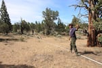 A squad boss demonstrates how to properly roll out a fire hose.