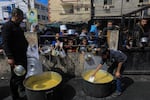 Displaced Palestinians gather to receive food at a donation point in Rafah on Thursday, March 7.