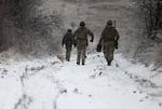 Ukrainian soldiers walk along a road not far from the Russian-occupied Ukrainian city of Bakhmut, Donetsk region, on Dec. 13.