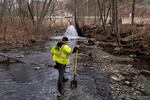 Ron Fodo, a member of the Ohio EPA Emergency Response team, checks for chemicals that have settled at the bottom of a creek following a train derailment in East Palestine, Ohio in February 2023.