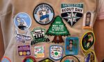 FILE - Patches cover the back of a Girl Scout's vest at a demonstration of some of their activities in Seattle, June 18, 2018. A federal judge, Thursday, April 7, 2022, tossed out a lawsuit in which the Girl Scouts claim that the Boy Scouts are creating marketplace confusion and damaging their recruitment efforts through their use of words such as "scouts" and "scouting." (AP Photo/Elaine Thompson, File)
