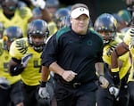 FILE - In this Oct. 21, 2010 file photo, Oregon head coach Chip Kelly runs onto the field with his team before an NCAA college football game against UCLA in Eugene, Ore. The Ducks are ranked fifth in the Associated Press preseason college football poll released on Saturday, Aug. 18, 2012.