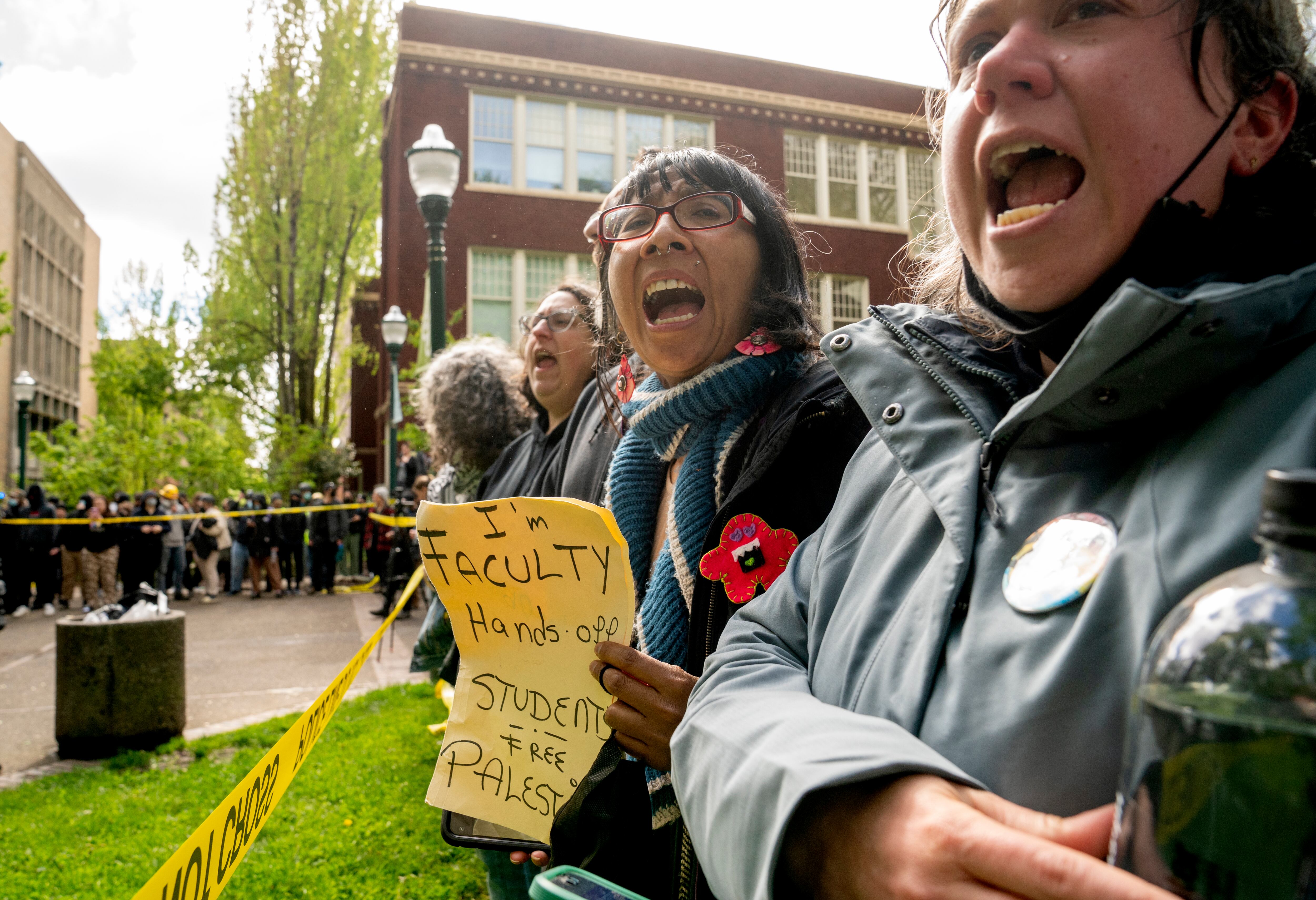 PSU faculty link arms and chant as they watch law enforcement teams clear protesters from Portland State University’s Branford Price Millar Library, May 2, 2024. Demonstrators protesting the war in Gaza have occupied the library since Monday evening.