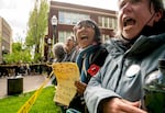 PSU faculty link arms and chant as they watch law enforcement teams clear protesters from Portland State University’s Branford Price Millar Library, May 2, 2024. Demonstrators protesting the war in Gaza had occupied the library since Monday evening.