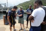 Special Operations Navy Diver Matthew Kelly (left) in Scuba gear on a training mission with divers from Trinidad and Tobago in 2012.