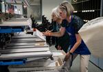 Volunteers Karen Arabas, left, and Diane Roth collects ballots after they go through a processing machine at the Marion County Clerk's office in Salem, Ore., on May 18, 2026.