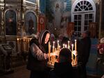 A woman lights candles during an Orthodox church service in Pavlohrad, Ukraine, on Oct. 20.