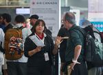 An Air Canada agent, left, talks with a man as Air Canada flight attendants strike at Montreal-Pierre Elliott Trudeau International Airport in Montreal, Saturday, Aug. 16, 2025.
