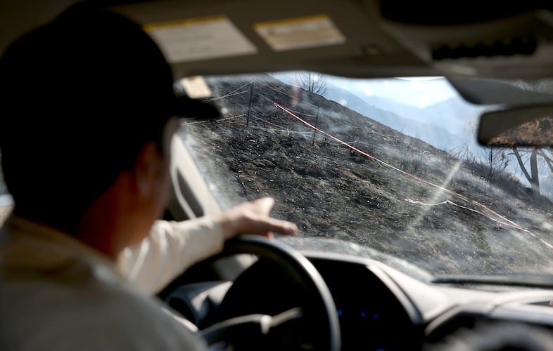Jared Smull points out burned land at the beginning of the drive into Rye Valley, where he and his family grazed their cattle for many years before the Durkee fire, July 31, 2024. The Smull family lost about 15 cows and thousands of acres of grazeable land in the fire.