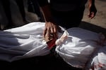 A Palestinian man mourns over the body of a child killed in the Israeli bombardment of the Gaza Strip at Nasser Hospital in Khan Younis on Jan. 22.