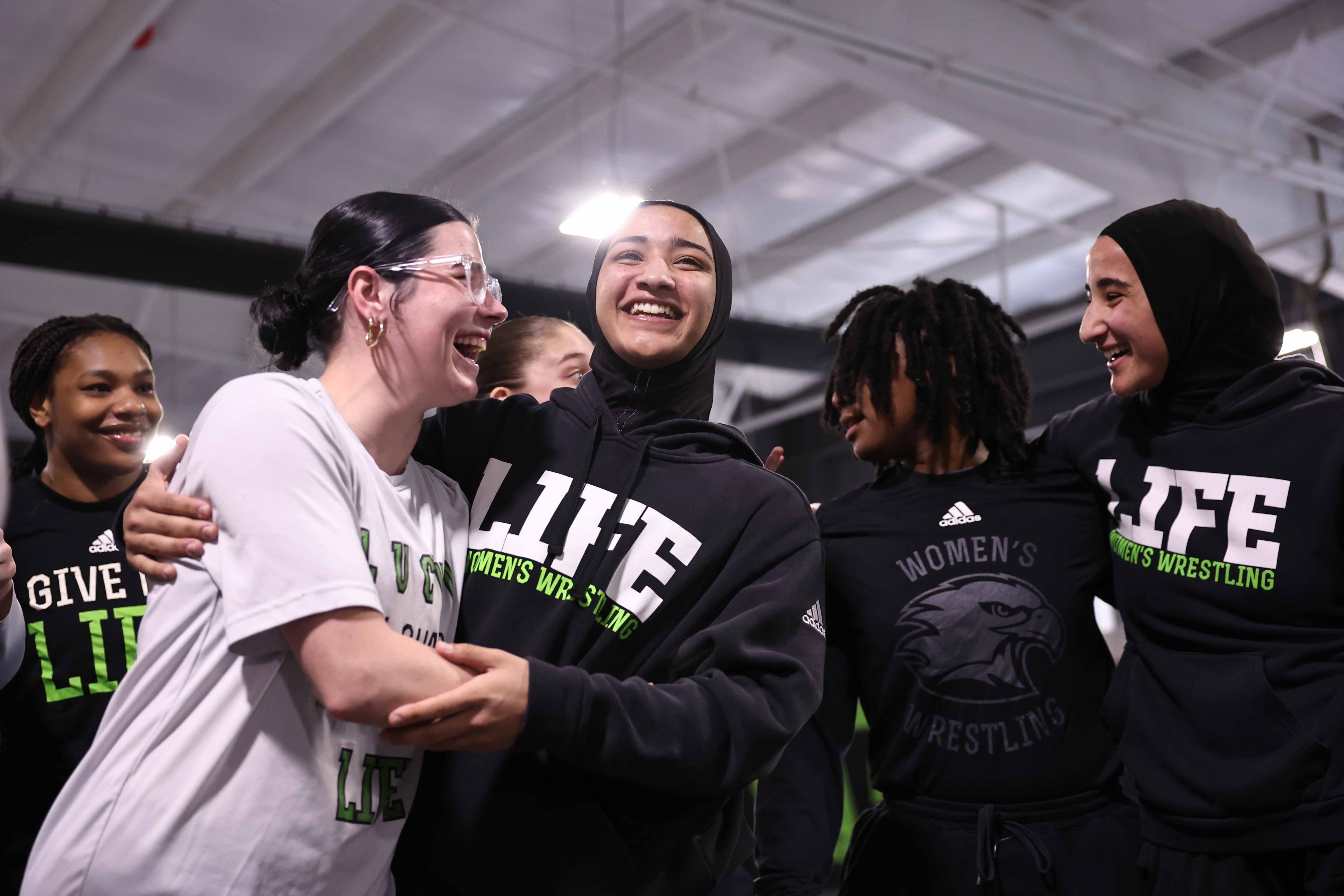 Zaynah McBryde (center) and sister Jamilah (right) celebrate with teammates after finding out that USA wrestling would let them compete in trials.