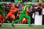 Oregon running back Travis Dye (26) gets past Oregon State defensive back Alex Austin (5) and heads to the end zone during the first quarter of an NCAA college football game Saturday, Nov. 27, 2021, in Eugene, Ore.