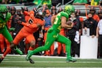 Oregon running back Travis Dye (26) gets past Oregon State defensive back Alex Austin (5) and heads to the end zone during the first quarter of an NCAA college football game Saturday, Nov. 27, 2021, in Eugene, Ore.