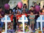 People visit memorials for victims of a mass shooting at Robb Elementary School in Uvalde, Texas. Nineteen children and two adults were killed after a man entered the school through an unlocked door and barricaded himself in a classroom where the victims were located. Law enforcement officers waited in the hallway for over an hour before entering the classroom and confronting the gunman. 