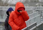 Pedestrians walking down the ramp at the Hollywood Max train station overpass in Portland shield their faces from the cold in January 2024.