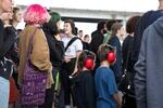 Two kids wear soundproofing earmuffs while standing in a crowd of Portlanders twice their size and age. PDX Pop Now! is a free and all-ages festival taking place underneath the Hawthorne Bridge on July 22-24.