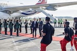 Britain's Prime Minister Keir Starmer, center left and a South African official watch the Fire and Ivory Pantsula dance group perform upon his arrival at the OR Tambo International airport in Ekurhuleni on Friday, Nov. 21, 2025 ahead of the G20 leaders' Summit.