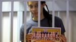 rittney Griner holds a picture of her Russian basketball team as she stands inside a defendants' cage before a court hearing in Khimki, outside Moscow, on Thursday.