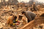 Robert Lara, left, looks for belongings along with his stepfather after the Eaton Fire burns in Altadena, Calif., Thursday, Jan. 9, 2025.