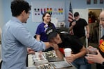 Hillsboro City Council candidate Dorian Russell, center right, talks with Gabriel Mendez, left, at the Washington County Democrats headquarters on Saturday, Sept. 12, 2026.
