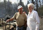 Dean and Betty Elliott look over the remains of their charred house. The Canyon Creek Fire destroyed their home of 53 years.
