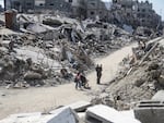 People stand amid rubble in the Jabalia refugee camp, northern Gaza Strip, on July 21.