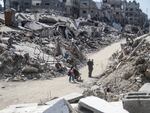 People stand amid rubble in the Jabalia refugee camp, northern Gaza Strip, on July 21.