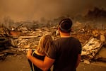 FILE - Megan Mantia, left, and her boyfriend Thomas, return to Mantia's fire-damaged home after the Eaton Fire swept through, Wednesday, Jan. 8, 2025 in Altadena, Calif.