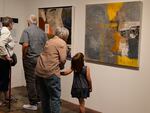 An elder holds the hand of a young child as they talk about a painting at the Sept. 19th opening for “Citizen Fellow: Art as Archive and Memory,” an exhibition at the Center for Native Arts and Cultures that runs through November.