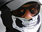 The Pride flag is reflected in the glasses of a white nationalist who came to protest at the LGBTQ+ community's "Pride in the Park" event in Coeur d'Alene, Idaho, on June 11, 2022.