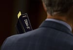 Prosecutor Don Rees holds a copy of the Diagnostic and Statistical Manual of Mental Disorders, or DSM, at the Multnomah County Courthouse in Portland, Ore., Feb. 12, 2020.