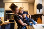 Emily Calabro lifts her daughter, Magnolia, 1, from the sink after dusting flour off her pants while baking at home in Vancouver, Wash., Thursday, April 2, 2020. Calabro and her husband, a firefighter, chose to send their daughter to stay with family in Kansas as fears grew about first responders' exposure to COVID-19.