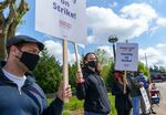 Justin Ringle, a grad student at the Oregon Institute of Technology, center, stands on the picket line in front of the Wilsonville campus, April 27, 2021.
