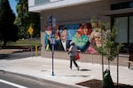 A resident of M Carter Commons walks past the mural dedicated to Margaret Carter.
