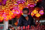 An ethnic Chinese worshiper wearing a face mask to help curb the spread of the coronavirus prays to celebrate the Lunar New Year at a temple in Jakarta, Indonesia on Monday, Jan. 31, 2022. People across Asia prepared Monday for muted Lunar New Year celebrations amid concerns over the coronavirus and virulent omicron variant, even as increasing vaccination rates raised hopes that the Year of the Tiger might bring life back closer to normal.