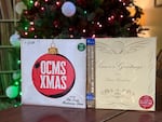 Two holiday records sit in front of a Christmas tree at JT Griffith's home in Portland, Ore. on Dec 20, 2025. Songs from "OCMS XMAS" by Old Crow Medicine Show (left) and "Season's Greetings" from Tatsuro Yamashita are some of the standout selections in OPB's 2025 holiday music roundup.